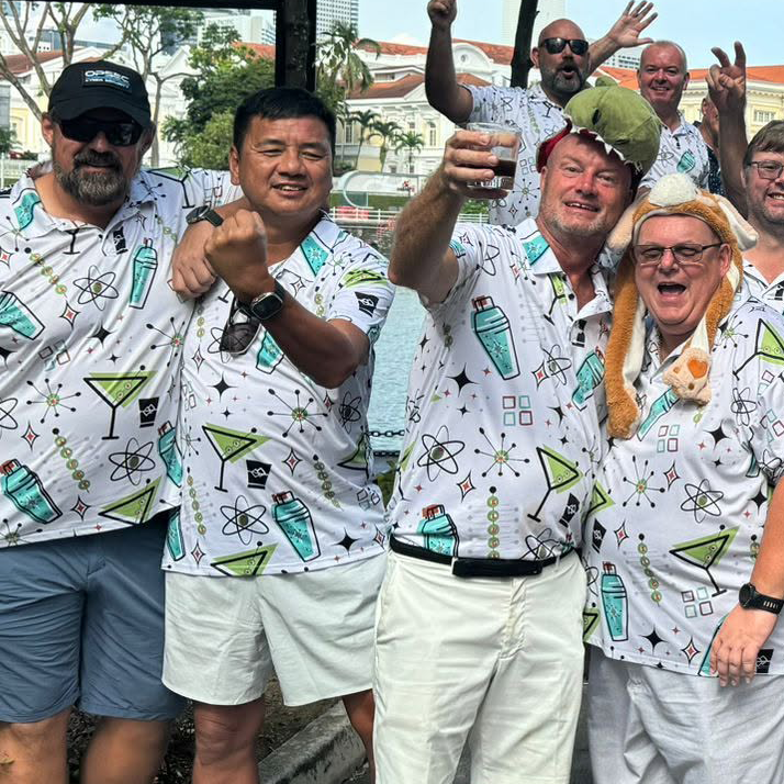 SL&GS golf society members celebrating in matching white cocktail-print après shirts