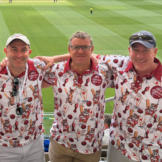 Tourists in matching white and claret Ashes print polos in the stands